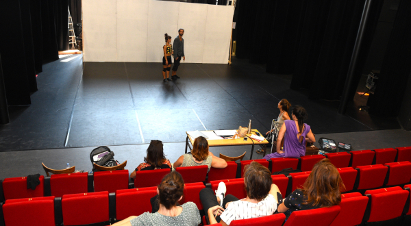 Photo de résidence de création dans un théâtre, avec équipe sur la scène et dans la salle