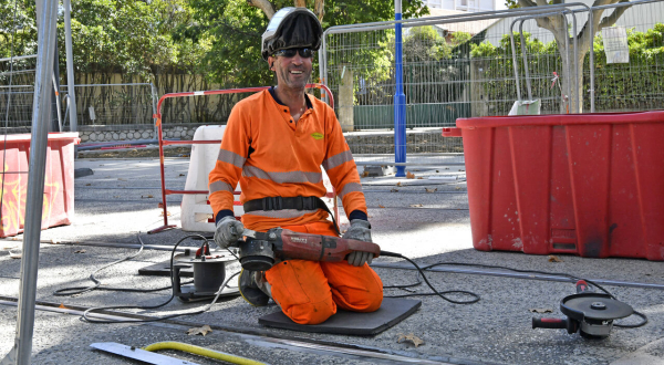 Lakhdar, soudeur sur le chantier de la ligne 5, avec une meuleuse. Rails, barrières de protection, végétation...