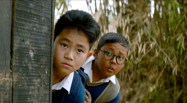 Extrait du film Boong, montrant deux petits garçons, se cachant derrière une porte