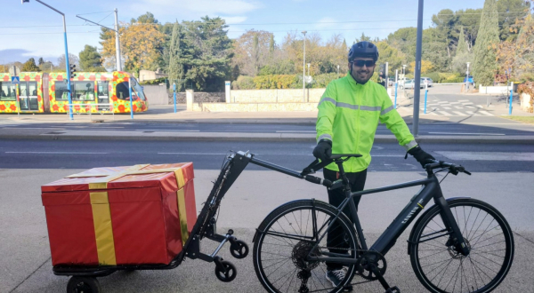 Deniz Ince avec son vélo-remorque décoré en paquet cadeau pour la période des fêtes
