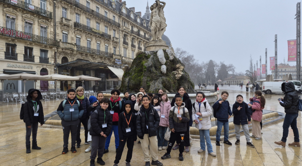 place de la Comédie, groupe d'écoliers, enseignants, fontaine des Trois Grâces, bâtiments, ciel gris
