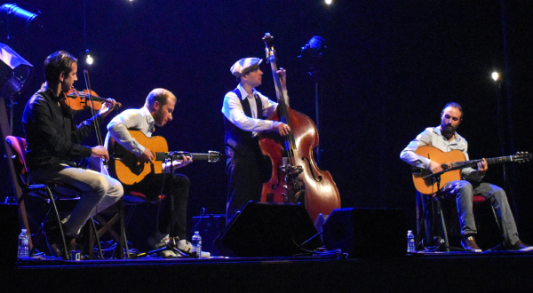 Quatuor violon guitares et contrebasse, du groupe Drom Blanchard sur scène dans une lumière bleue