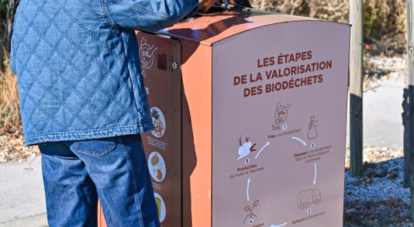 Personne vide biodéchets dans borne