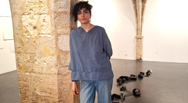 Portrait de Melika Sadeghzadeh debout contre un pilier de la galerie Saint-Ravy