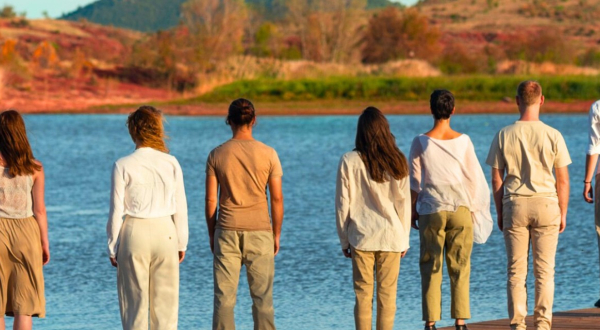 Danseurs debout, de dos, devant un lac