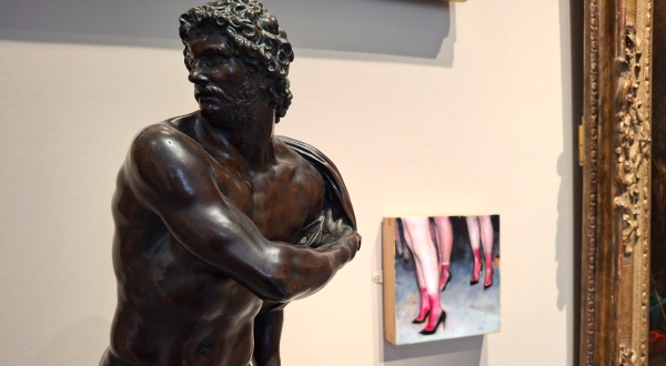 Buste de bronze d'un  personnage de mythologie semblant tourner la tête devant un petit tableau de femmes en talons rouges