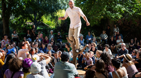 Un artiste du spectacle Pour Hêtre, en équilibre sur un tronc d'arbre